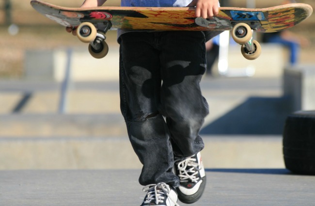 boy carrying a skateboard